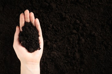 Photo of Woman with pile of fresh soil, top view