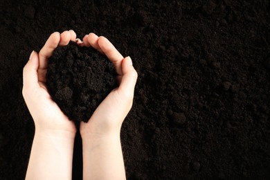 Photo of Woman with pile of fresh soil, top view