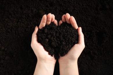 Photo of Woman with pile of fresh soil, top view