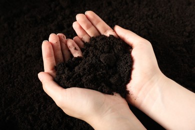 Photo of Woman with pile of fresh soil, closeup