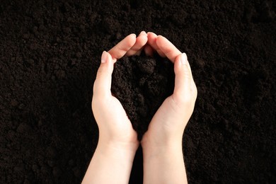 Photo of Woman with pile of fresh soil, top view