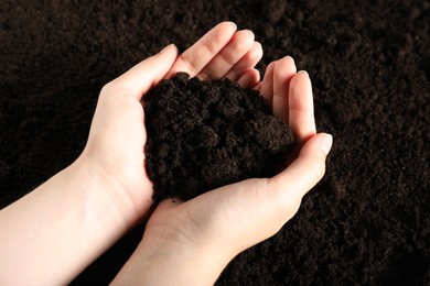Photo of Woman with pile of fresh soil, closeup