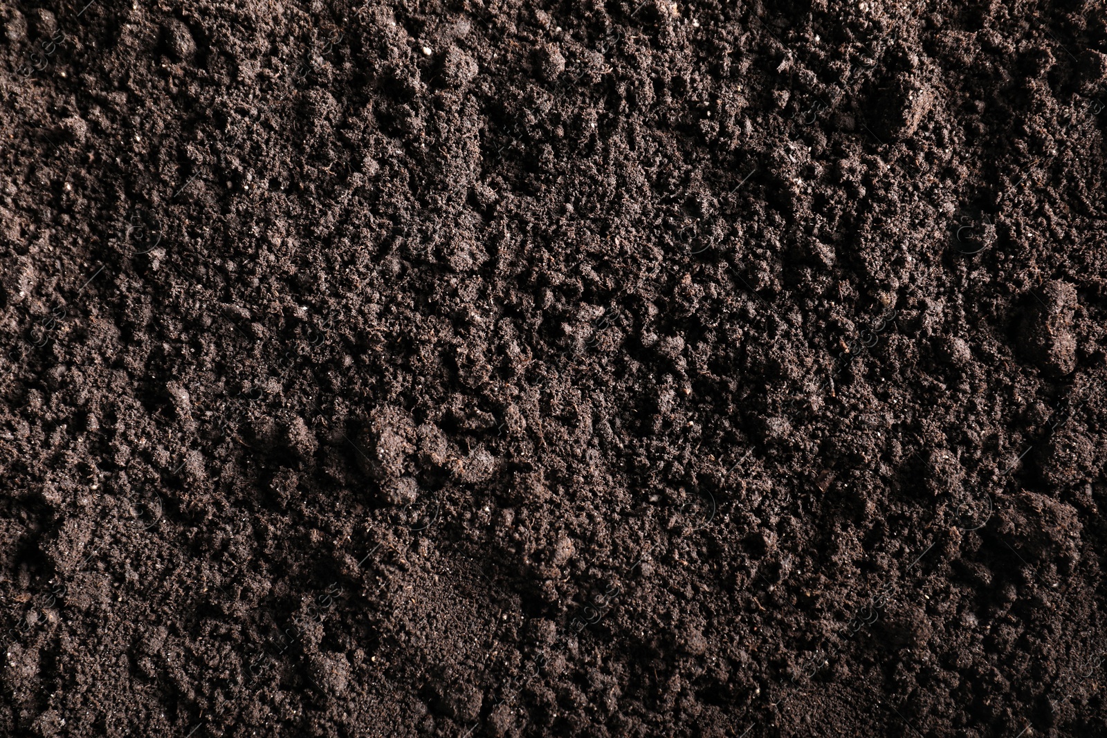 Photo of Fresh soil as background, top view. Organic matter