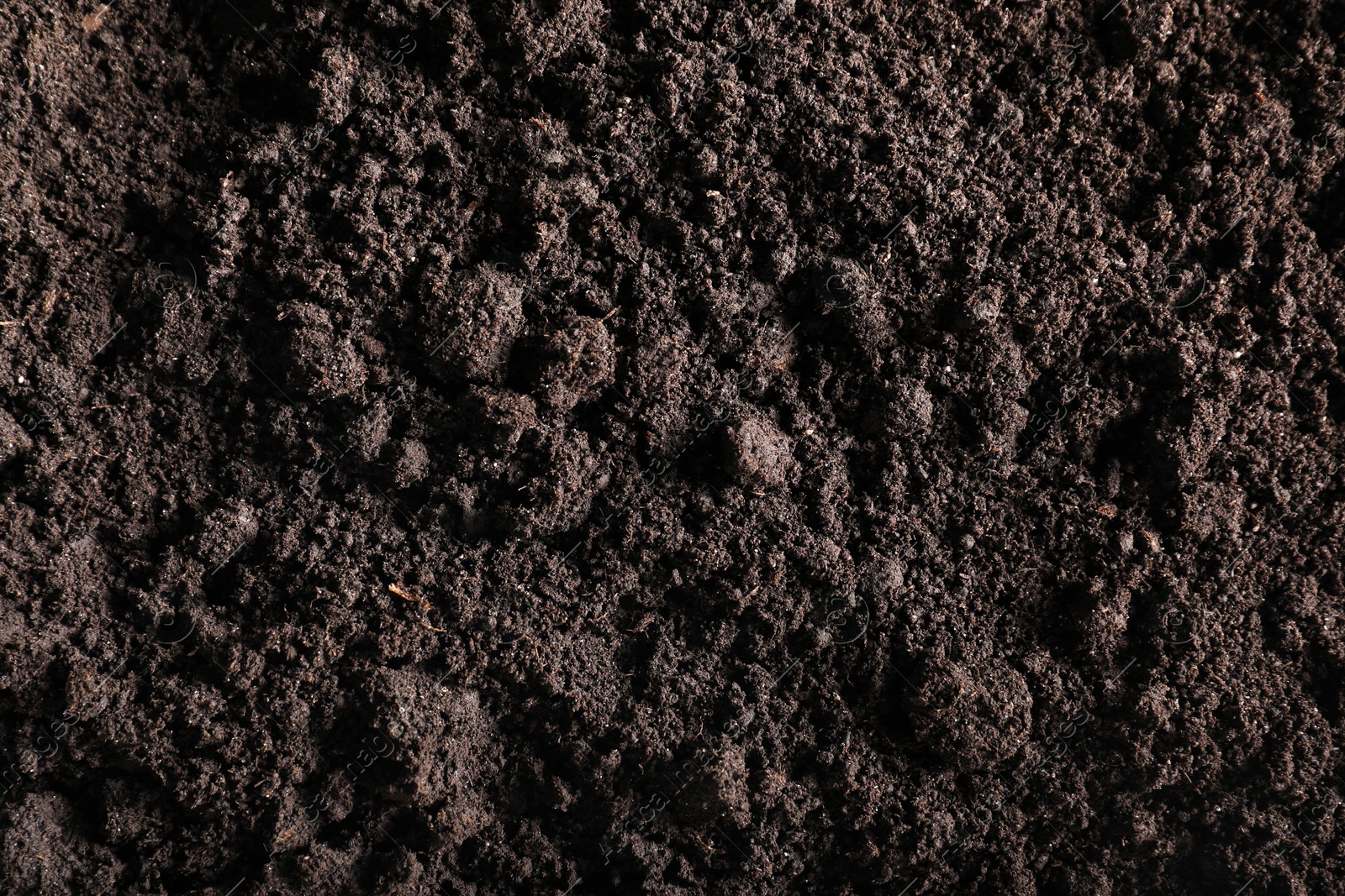 Photo of Fresh soil as background, top view. Organic matter