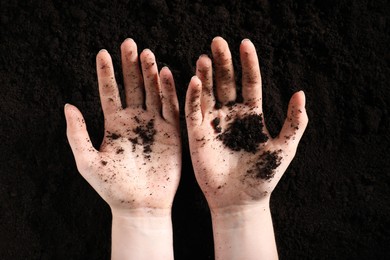 Photo of Woman with fresh soil, top view. Organic matter