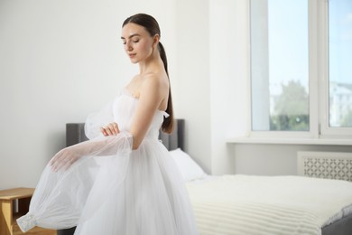 Photo of Dreams come true. Woman in beautiful wedding dress at home, space for text
