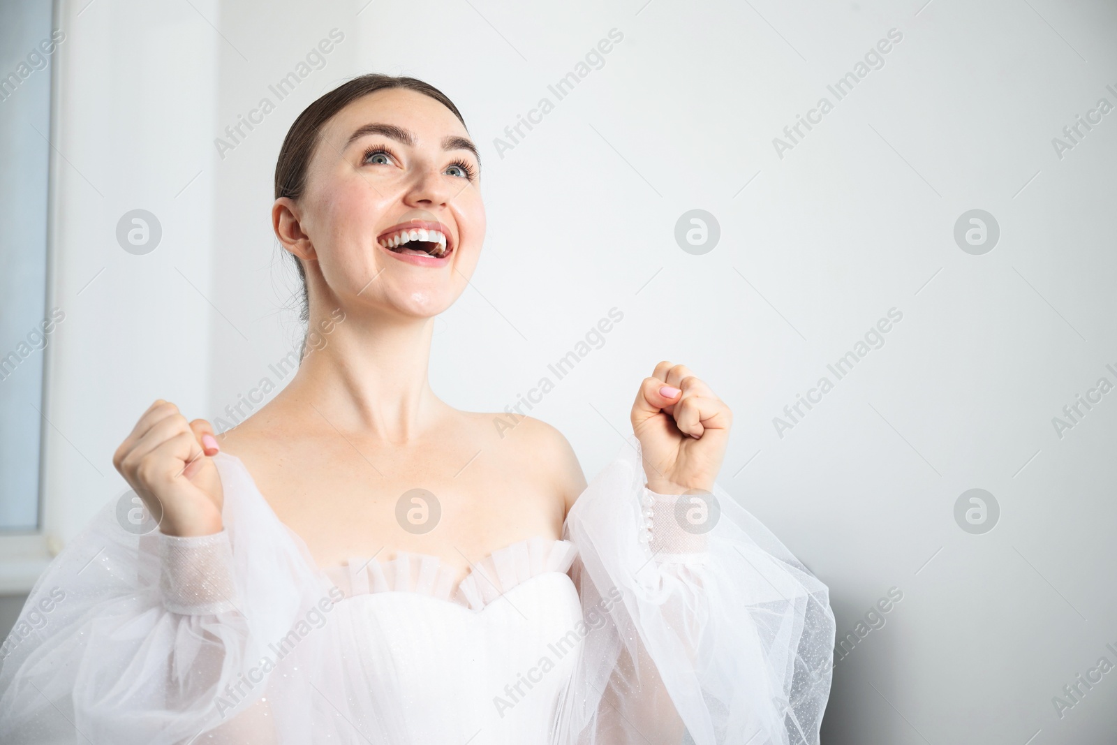 Dreams come true. Woman in beautiful wedding dress at home, space for text Photo of Dreams come true. Woman in beautiful wedding dress at home, space for text