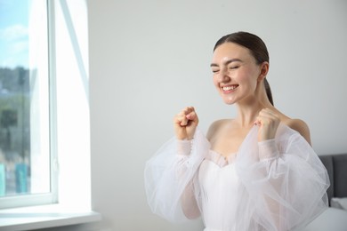 Photo of Dreams come true. Woman in beautiful wedding dress at home, space for text