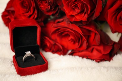 Photo of Dreams come true. Beautiful engagement ring in box and flowers on light plaid, closeup