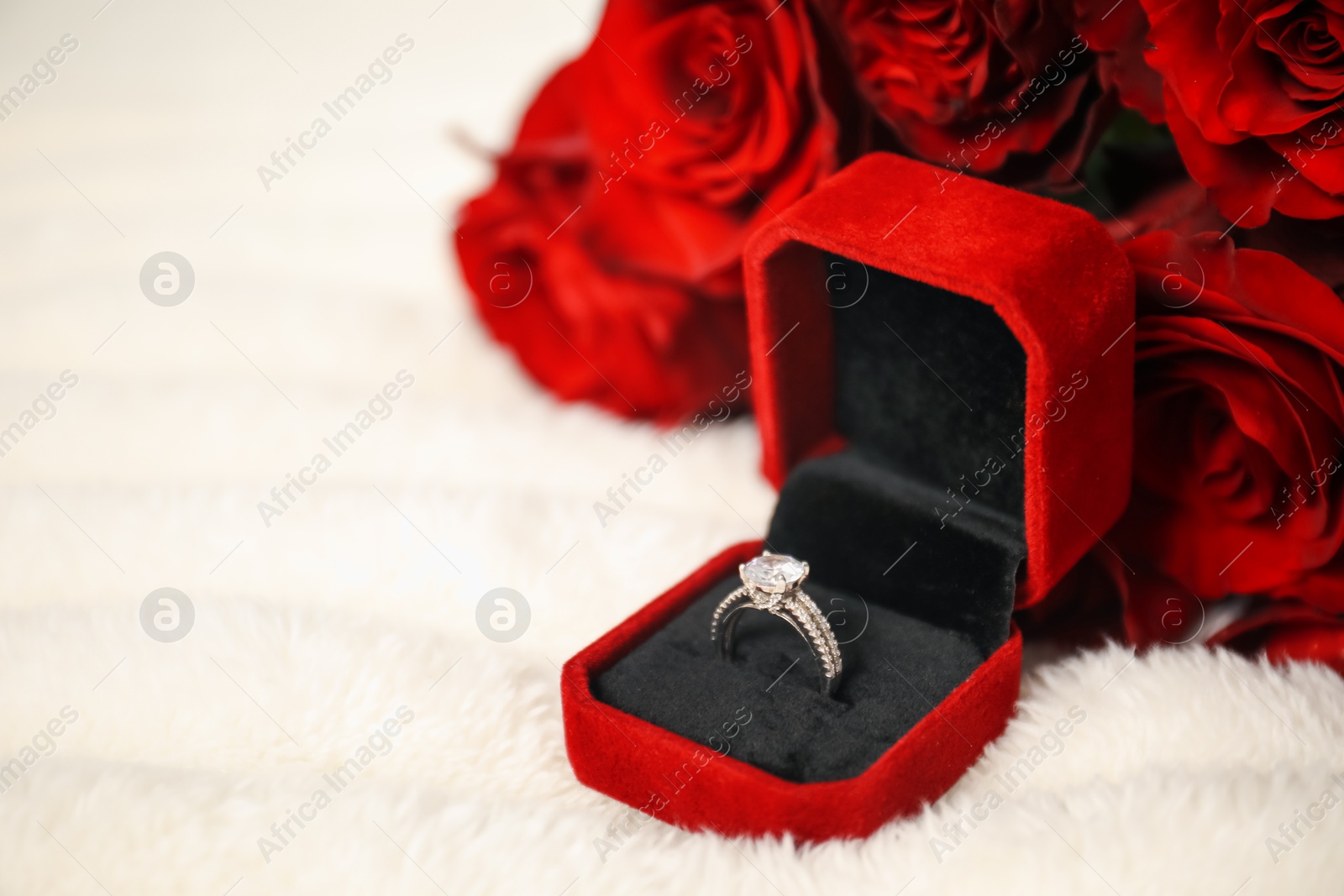 Photo of Dreams come true. Beautiful engagement ring in box and flowers on light plaid, closeup. Space for text