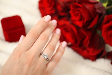 Photo of Dreams come true. Happy woman with engagement ring and beautiful bouquet indoors, closeup