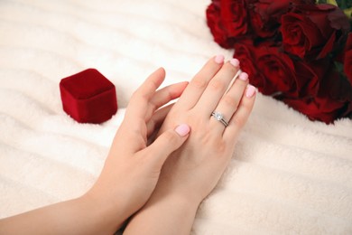 Photo of Dreams come true. Happy woman with engagement ring and beautiful bouquet indoors, closeup