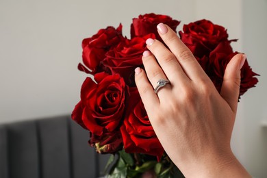Photo of Dreams come true. Happy woman with engagement ring and beautiful bouquet indoors, closeup