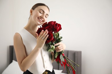 Photo of Dreams come true. Happy woman with engagement ring and beautiful bouquet indoors. Space for text