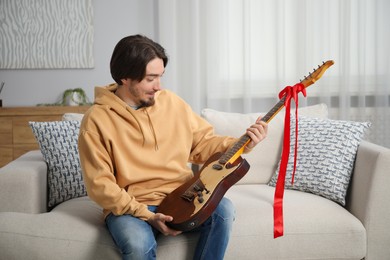 Photo of Dreams come true. Happy man with guitar at home