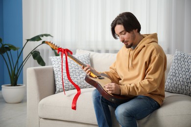 Photo of Dreams come true. Happy man with guitar at home