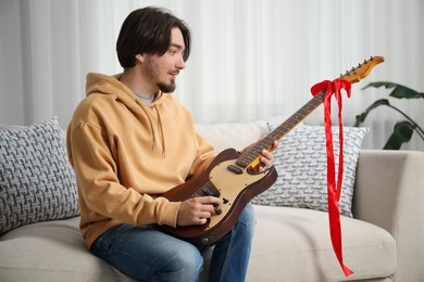Photo of Dreams come true. Happy man with guitar at home