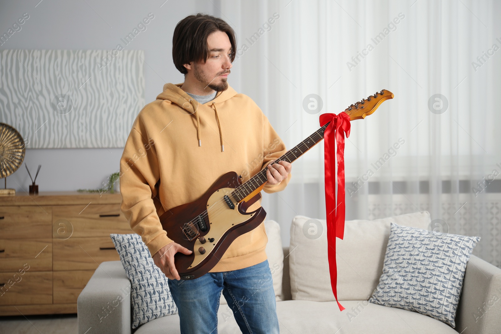 Dreams come true. Happy man with guitar at home Photo of Dreams come true. Happy man with guitar at home