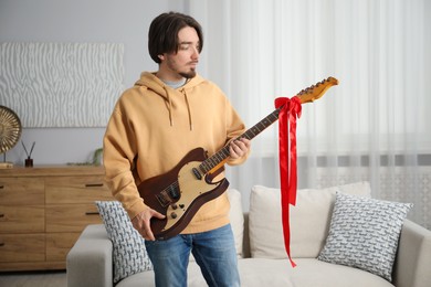 Photo of Dreams come true. Happy man with guitar at home