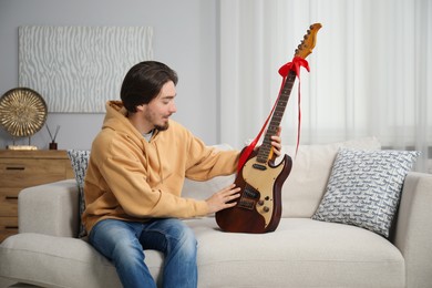 Photo of Dreams come true. Happy man with guitar at home