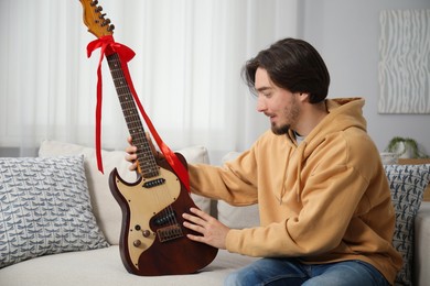 Photo of Dreams come true. Happy man with guitar at home