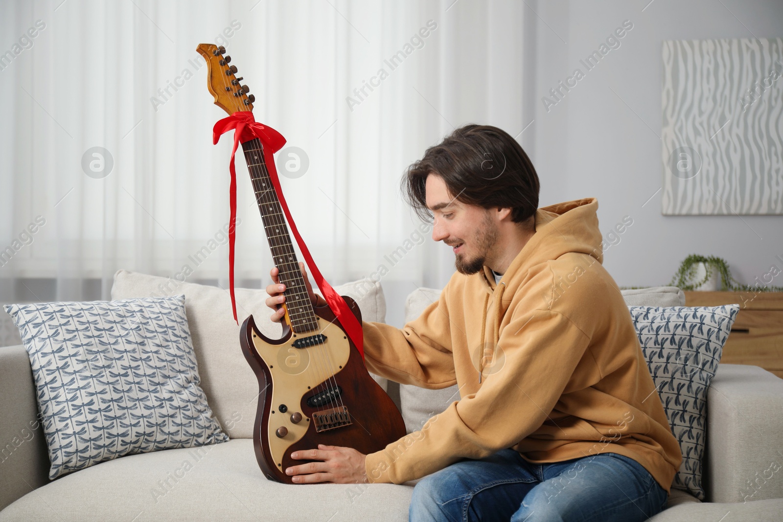 Dreams come true. Happy man with guitar at home Photo of Dreams come true. Happy man with guitar at home