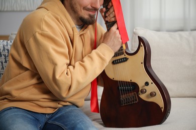 Photo of Dreams come true. Happy man with guitar at home, closeup