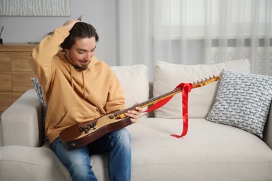Photo of Dreams come true. Excited man with guitar at home, space for text