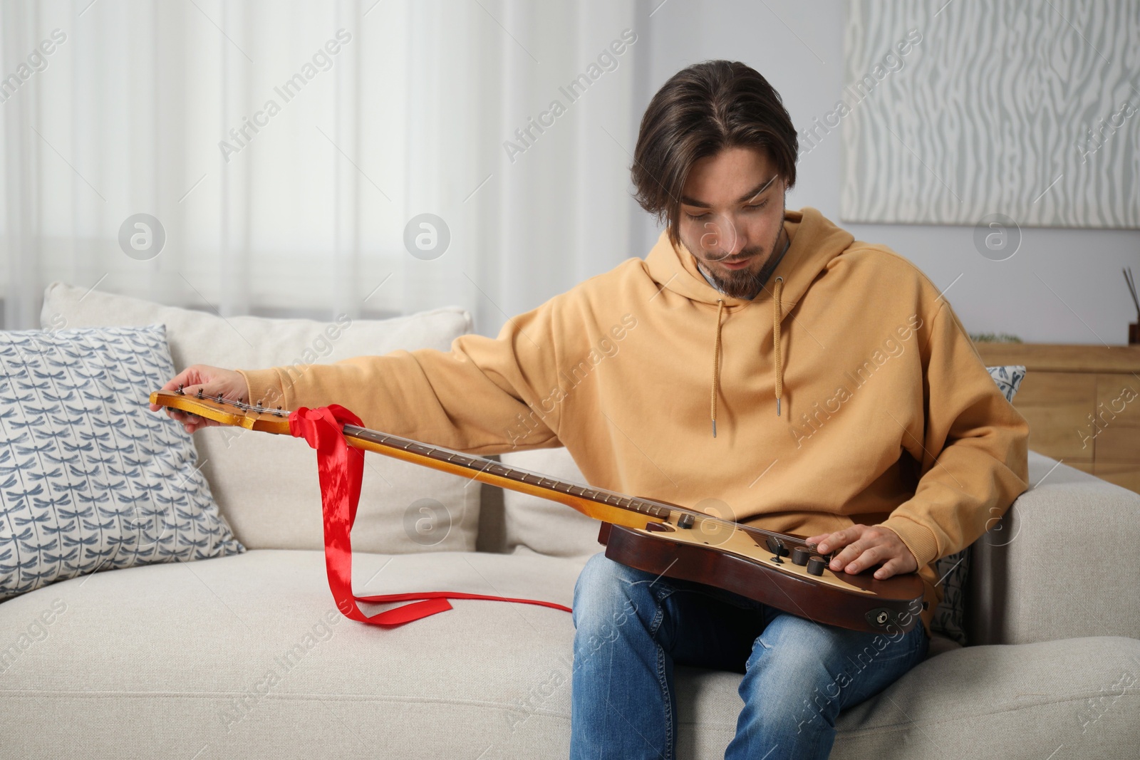 Dreams come true. Happy man with guitar at home, space for text Photo of Dreams come true. Happy man with guitar at home, space for text