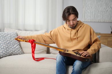 Photo of Dreams come true. Happy man with guitar at home, space for text