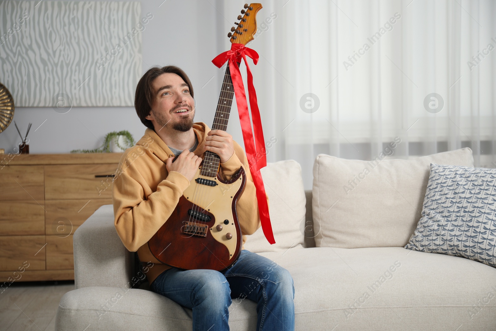 Dreams come true. Happy man with guitar at home, space for text Photo of Dreams come true. Happy man with guitar at home, space for text