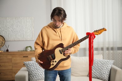 Photo of Dreams come true. Happy man with guitar at home