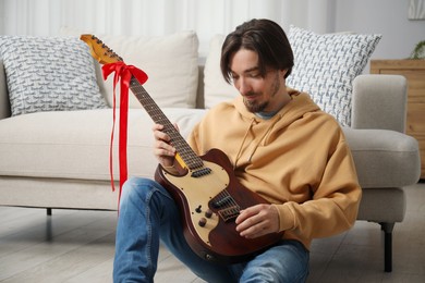 Photo of Dreams come true. Happy man with guitar at home