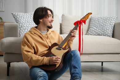 Photo of Dreams come true. Happy man with guitar at home