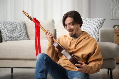 Photo of Dreams come true. Happy man with guitar at home