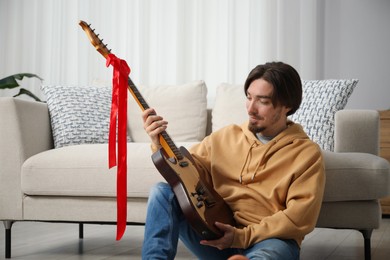 Photo of Dreams come true. Happy man with guitar at home