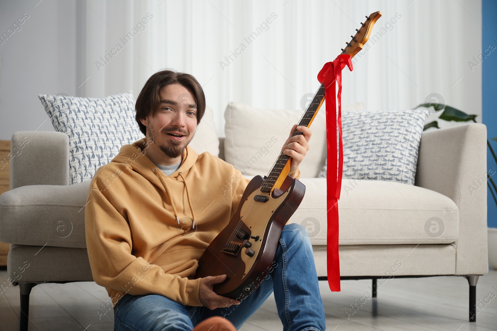 Photo of Dreams come true. Excited man with guitar at home