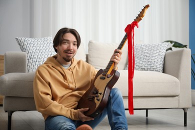 Photo of Dreams come true. Excited man with guitar at home