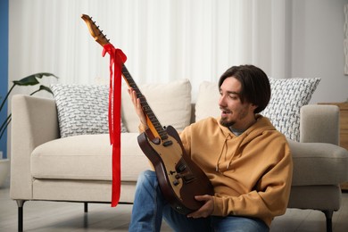 Photo of Dreams come true. Excited man with guitar at home