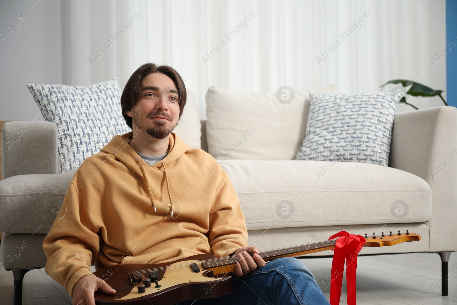 Dreams come true. Happy man with guitar at home, space for text Photo of Dreams come true. Happy man with guitar at home, space for text
