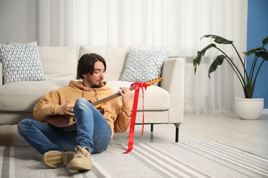 Photo of Dreams come true. Happy man with guitar at home, space for text