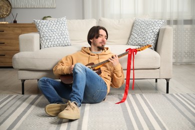 Photo of Dreams come true. Happy man with guitar at home