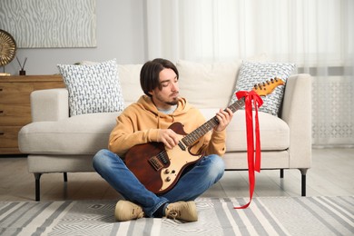 Photo of Dreams come true. Happy man with guitar at home