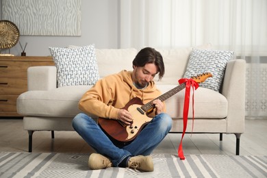 Photo of Dreams come true. Happy man with guitar at home