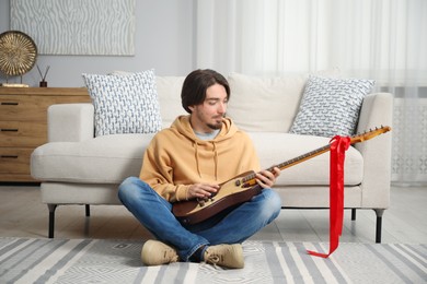 Photo of Dreams come true. Happy man with guitar at home