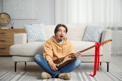 Photo of Dreams come true. Excited man with guitar at home