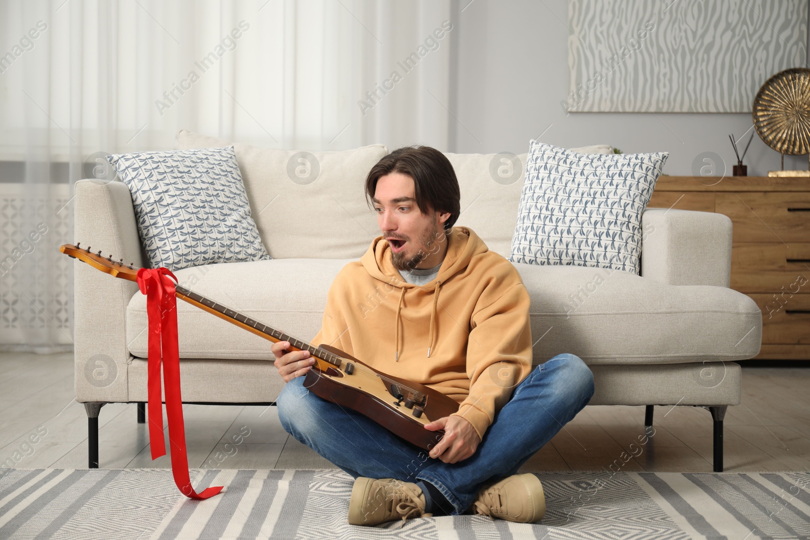 Photo of Dreams come true. Excited man with guitar at home