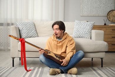 Photo of Dreams come true. Excited man with guitar at home