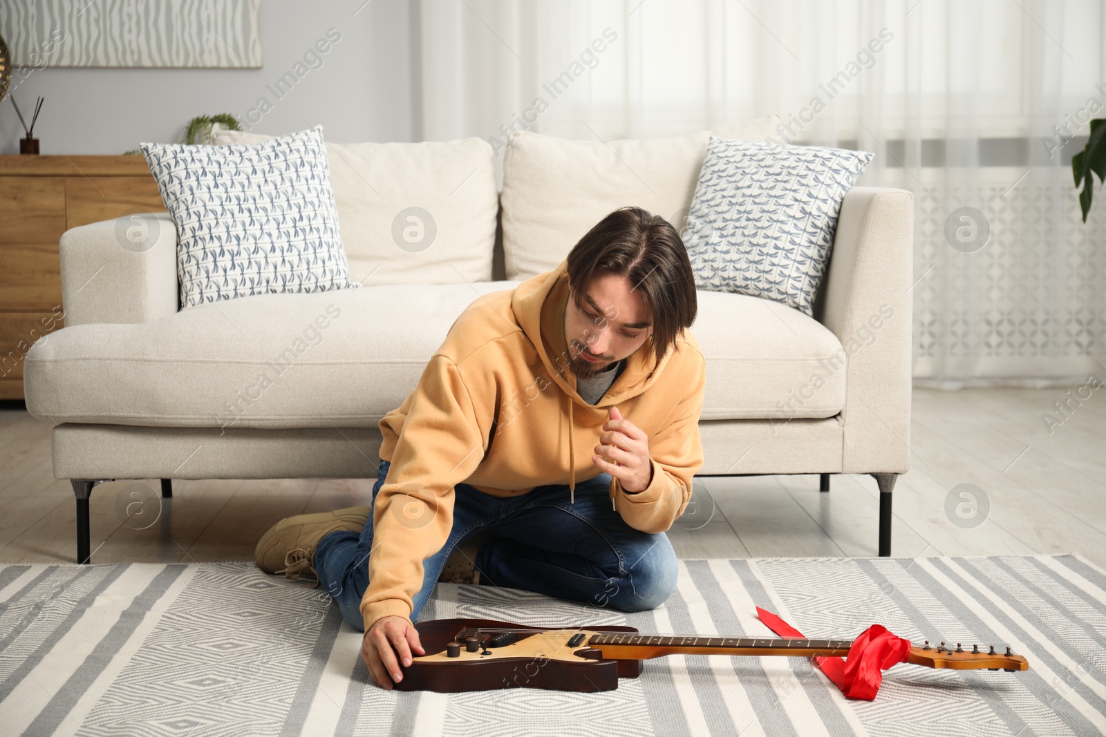 Dreams come true. Happy man with guitar at home Photo of Dreams come true. Happy man with guitar at home