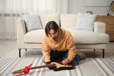Photo of Dreams come true. Happy man with guitar at home